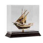 metal dhow boat model golden colour in glass acrylic case with wooden base supplier of traditional gifts in dubai
