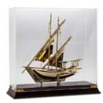 metal dhow boat model golden colour in glass acrylic case with wooden base supplier of traditional gifts in dubai