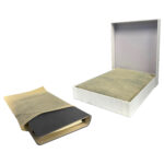 Open white box with wrapped black notebook.