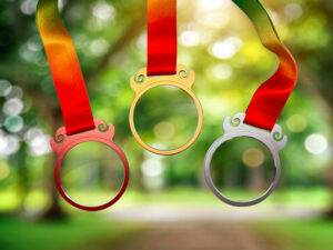Glass medals with metallic frame on ribbon in sunlight